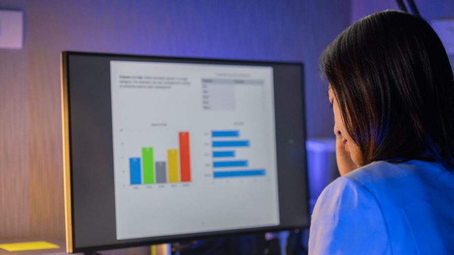 Mulher concentrada analisando dados no computador