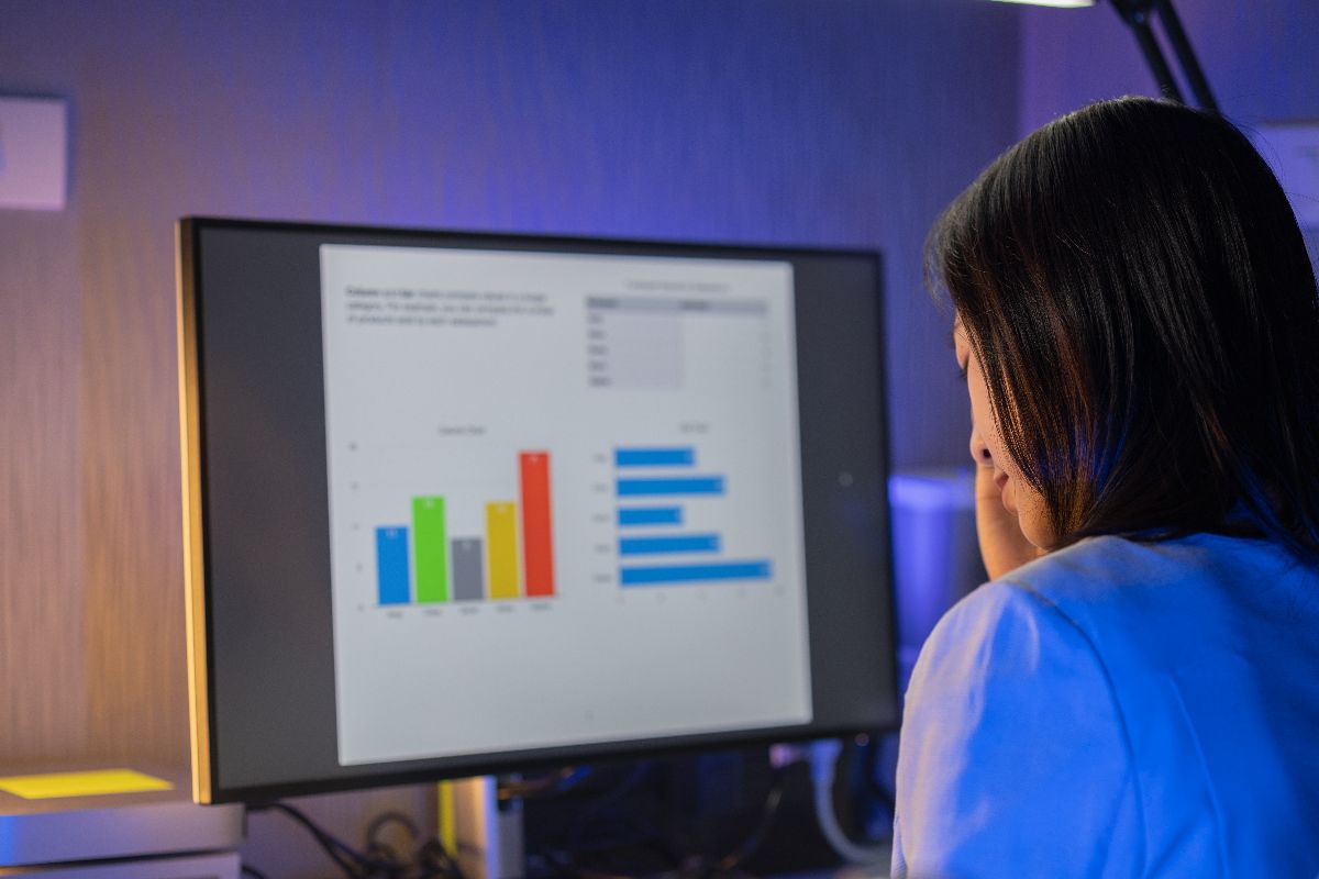 Mulher concentrada analisando dados no computador