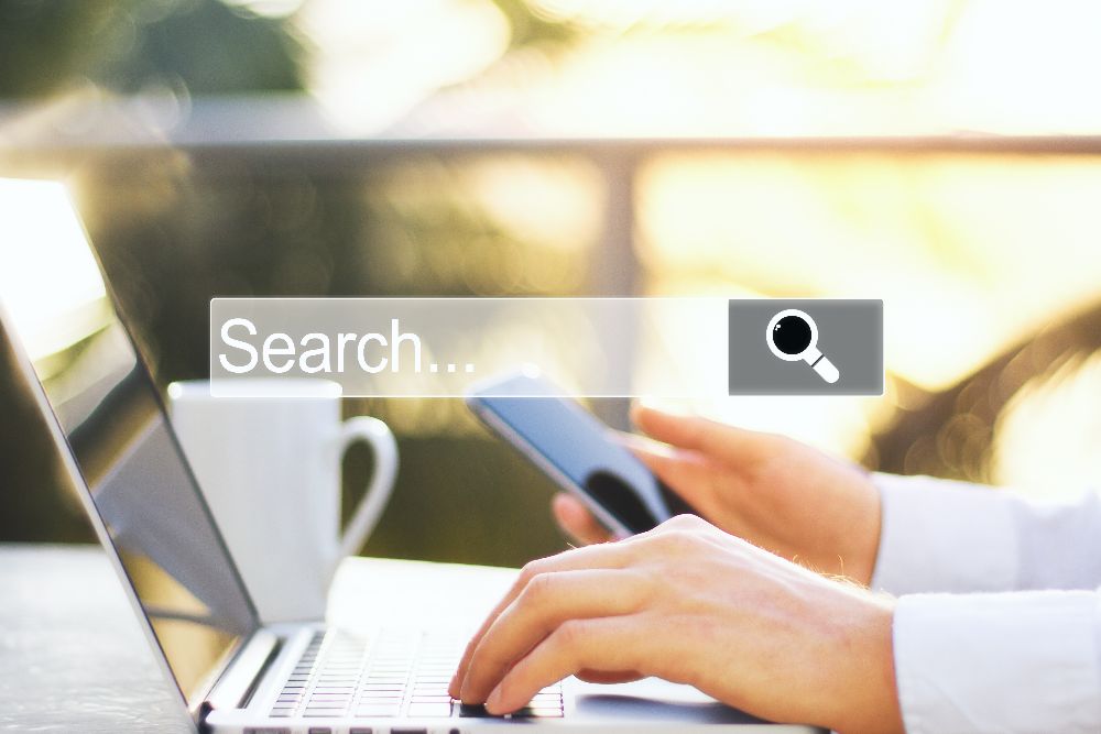 Mãos usando smartphone e notebook com navegador de pesquisa