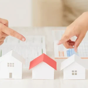 Maquete de casas e pessoas apontando