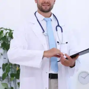 homem sorridente com trajes de médico e prancheta